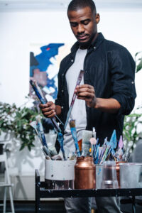 Male artist working in their studio on a painting